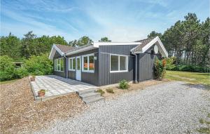 a black tiny house on a gravel lot at Stunning Home In Ebeltoft With 4 Bedrooms, Sauna And Wifi in Ebeltoft