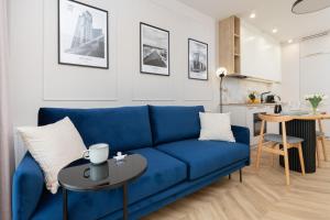 a living room with a blue couch and a table at Sienna Grobla Apartment View of the Motława by Renters in Gdańsk