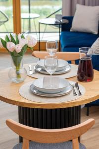 a table with plates and glasses and flowers on it at Sienna Grobla Apartment View of the Motława by Renters in Gdańsk