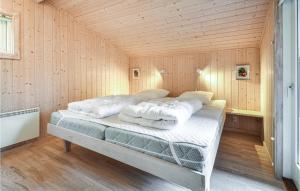 Torup StrandにあるAmazing Home In Fjerritslev With 4 Bedrooms, Sauna And Wifiの木製の部屋にベッド1台が備わるベッドルーム1室があります。