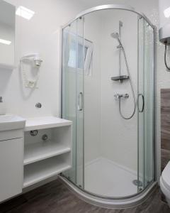 een badkamer met een douche met een glazen wand bij Apartmani Vegas in Novalja