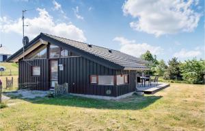 una pequeña casa negra con una mesa de picnic en un campo en 3 Bedroom Stunning Home In Ebeltoft, en Ebeltoft