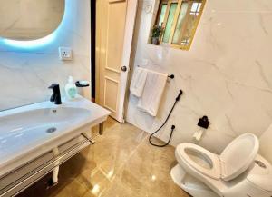 a bathroom with a white sink and a toilet at Homtel Signature Suites in Islamabad
