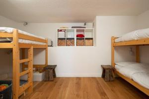 a room with two bunk beds and wooden floors at L'Arc-en-Ciel - Appartement sur les hauteurs du Mottaret avec accès aux pistes in Les Allues