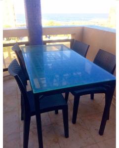 una mesa azul y sillas en el balcón en Terrasse vue mer, plage à 100m, 3 pièces, en Tel Aviv