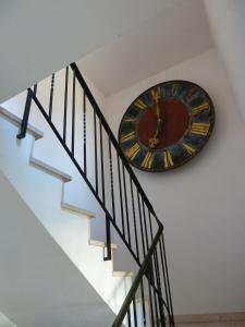 a large clock on the wall next to a staircase at Im Efeu 