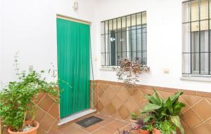 a green door on the side of a building with plants at 1 Bedroom Nice Apartment In Chipiona in Chipiona