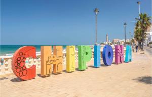 a row of colorful signs on a beach at 1 Bedroom Nice Apartment In Chipiona in Chipiona