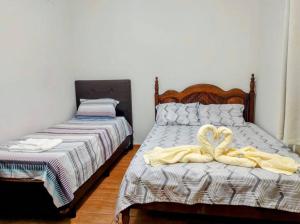 een slaapkamer met 2 bedden en handdoeken bij Básico e Aconchegante in Itajubá