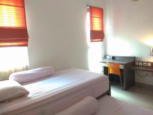 sypialnia z 2 łóżkami, biurkiem i biurkiem w obiekcie Omah Dixy Family Homestay by FH Stay w mieście Bantul