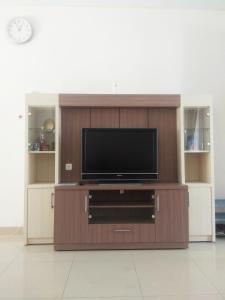 telewizor z płaskim ekranem w drewnianym centrum rozrywki w obiekcie Omah Dixy Family Homestay by FH Stay w mieście Bantul