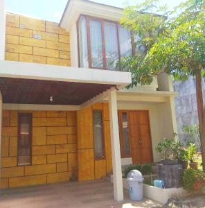 una casa con un porche delantero y un edificio en Omah Dixy Family Homestay by FH Stay en Bantul