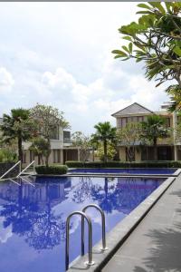 a swimming pool at a resort with blue water at Omah Dixy Family Homestay by FH Stay in Bantul