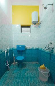 y baño con aseo azul y lavamanos. en The Last Stop Backpackers Hostel en Auroville