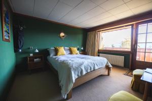 a bedroom with a bed and a green wall at Colorado Riders Chalet in Crans-Montana
