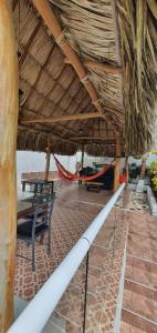 un pabellón con un banco y una hamaca bajo un techo de paja en Cabaña villa kary en Barranquilla