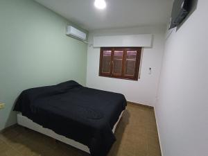 Habitación pequeña con cama y ventana en Hotel FG en Termas de Río Hondo