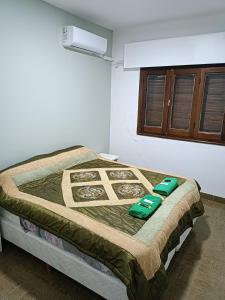 Una cama en una habitación con almohadas verdes. en Hotel FG en Termas de Río Hondo