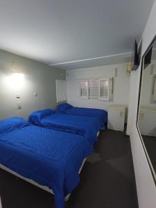 Zimmer mit vier blauen Betten in der Unterkunft Hotel FG in Termas de Río Hondo