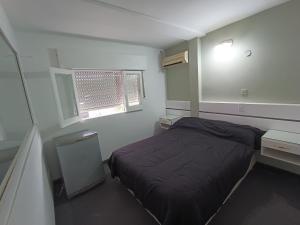 ein kleines Schlafzimmer mit einem Bett und einem Fenster in der Unterkunft Hotel FG in Termas de Río Hondo