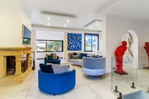 ein Wohnzimmer mit blauen Sofas und einer Statue in der Unterkunft Villa Jaliel 250 m2 - 12 pers. plein coeur de Cannes in Cannes