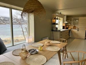 拉姆貝格的住宿－Casa Lofoten Ramberg Beach Sauna Surfing Kvalvika Reine，一张带椅子的木桌和一间享有海景的厨房