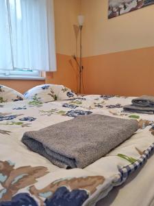 a bed with a blanket on top of it at Apartmán Nad hradem in Týnec nad Sázavou