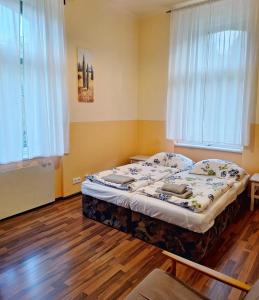 een slaapkamer met een bed in een kamer met houten vloeren bij Apartmán Nad hradem in Týnec nad Sázavou
