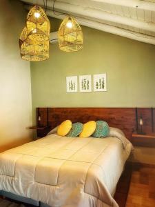 a bedroom with a bed with two pillows and two lights at Cortaderas Suites & Tenis in Nono