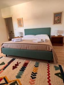 a bed with a green headboard in a bedroom at Casa Azul Apartment in Porto San Giorgio