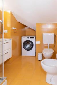 a bathroom with a toilet and a washing machine at Casa Azul Apartment in Porto San Giorgio