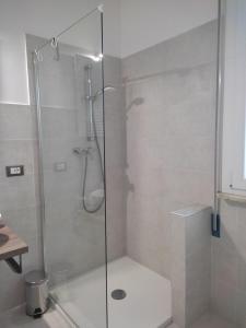 y baño con ducha y puerta de cristal. en B&B Il giardino segreto, 