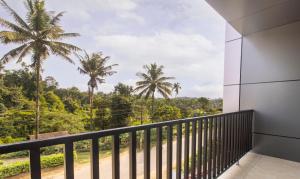 einen Balkon mit Palmen im Hintergrund in der Unterkunft Treebo Trend The Rove in Madikeri