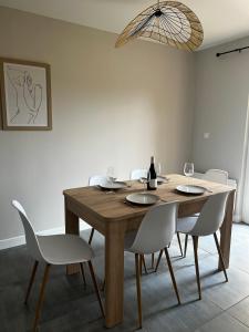 Un comedor con una mesa de madera y sillas blancas. en Scorfel Lodge, Iconic, Spa, sauna & terrasse, en Trégastel