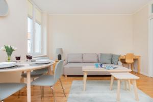 una sala de estar con un sofá y una mesa en Warm & Bright City Vibe Apartment with 1 Bedroom in Gdańsk-Wrzeszcz by Noclegi Renters, en Gdansk
