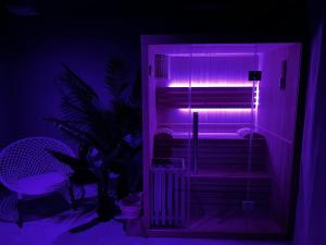 a room with a purple light in a room at Iconic, Spa, sauna & terrasse in Trégastel +17 photos