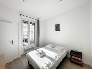 ein weißes Schlafzimmer mit einem Bett und einem Fenster in der Unterkunft cosy appart - Préfecture Lyon - Servient 1 in Lyon