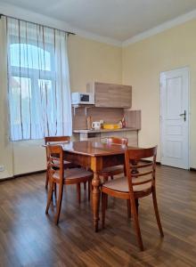 a dining room with a table and chairs and a kitchen at Apartmán Nad hradem in Týnec nad Sázavou