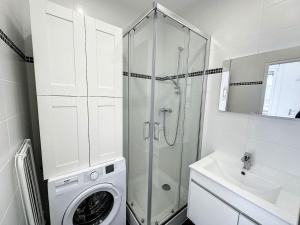 ein weißes Bad mit einer Dusche und einer Waschmaschine in der Unterkunft cosy appart - Préfecture Lyon - Servient 1 in Lyon
