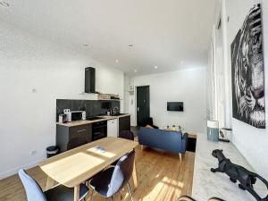 ein Wohnzimmer mit einem Holztisch und einer Küche in der Unterkunft cosy appart - Préfecture Lyon - Servient 1 in Lyon