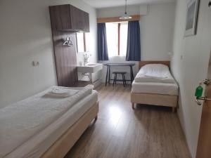 una camera d'albergo con due letti e un lavandino di Litla-Hof Guesthouse a Hof