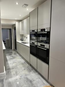 a kitchen with white cabinets and black appliances at The Kings Head in Chelmsford