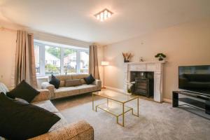 a living room with a couch and a television at Luxurious & Tranquil Riverside Getaway in Great Harwood