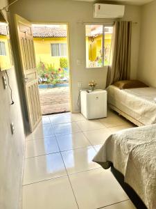 1 dormitorio con 2 camas y puerta abierta en Pousada Do Sol, en Parnaíba