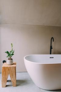 un bagno con vasca bianca e pianta in vaso di TerraSense Mountain Charm Retreat & Farm a Videmonte