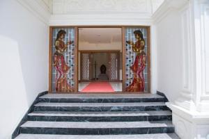 a staircase in a building with a glass door at The Grand White Palace in Sīrkāzhi