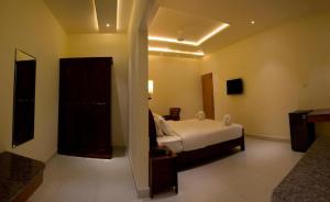 a hotel room with a bed and a bathroom at The Grand White Palace in Sīrkāzhi