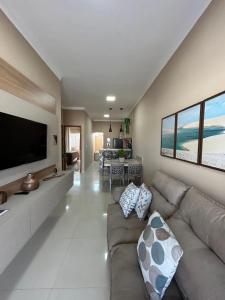 sala de estar con sofá y TV de pantalla plana en Dunas Residence - Casa 11, en Santo Amaro