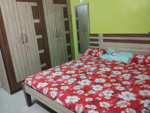 a bedroom with a bed with a red comforter at Asha vihara Phase-2 in Muzaffarpur