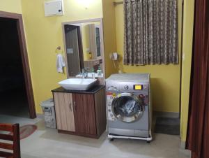 a bathroom with a washing machine and a sink at Asha vihara Phase-2 in Muzaffarpur